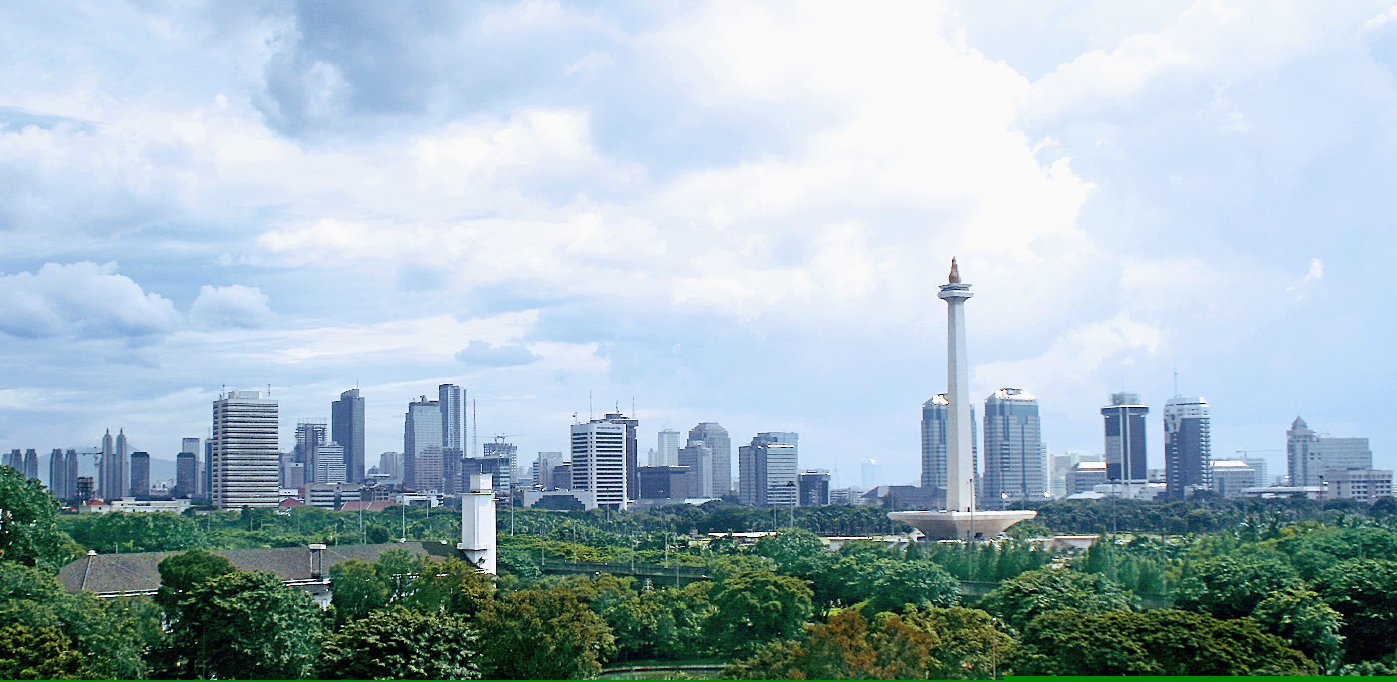 The National Monument rises above the Jakarta skyline and parkland.